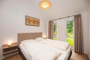 a bedroom with a large white bed and a window at Veluwepark de Bosgraaf in Apeldoorn +42 photos