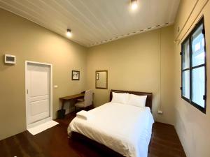 a bedroom with a bed and a desk and a window at Rest Inn Yaowarat - เรสอิน เยาวราช ไชน่าทาวน์ in Samphanthawong