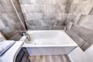 - Baño con bañera blanca y pared de azulejos en Le petit nid Rémois, en Reims 16 fotos más