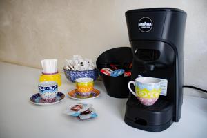 una macchinetta del caffè e tazze su un bancone di La Clessidra - Rome Ciampino Airport a Ciampino Altre 15 foto