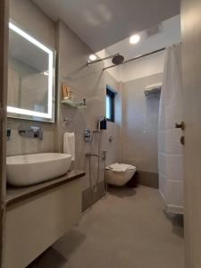 a bathroom with a sink and a toilet and a mirror at Hotel 24K Nagpur in Nagpur +10 photos