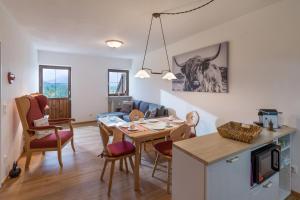 Una cocina y una sala de estar con mesa y sillas. en Erdgeschosswohnung 8 im Bergschlössl, en Oberaudorf