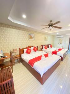 a bedroom with two beds with red pillows at Luang Prabang Golden Lotus Villa River View in Luang Prabang