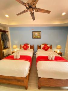 two beds in a room with a ceiling fan at Luang Prabang Golden Lotus Villa River View in Luang Prabang +60 photos