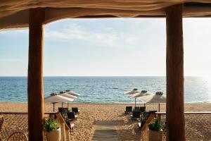 a group of tables and chairs on the beach at The Westin Resort, Costa Navarino in Romanu