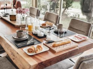 una mesa de madera con desayuno y café. en LV House & Gardens, en Carcassonne