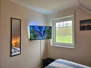 Schlafzimmer mit einem Flachbild-TV an der Wand in der Unterkunft Ferienhaus Liv in Biendorf