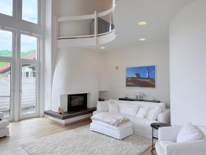 a white living room with a white couch and a fireplace at Casa Braun in Bodman-Ludwigshafen