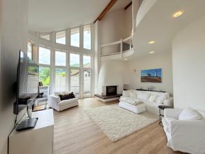 a living room with white furniture and a large window at Casa Braun in Bodman-Ludwigshafen