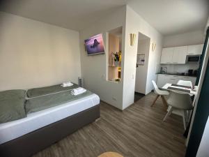 a small bedroom with a bed and a kitchen at bookVienna "Paula" Apartments in Vienna