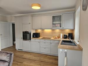 a kitchen with white cabinets and a sink at Ferienhaus Xena in Biendorf