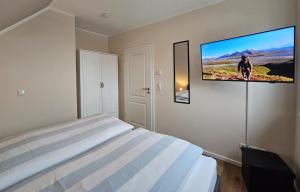 a bedroom with a bed and a tv on the wall at Ferienhaus Xena in Biendorf