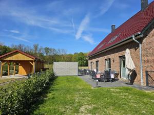 a backyard of a house with a table and chairs at Ferienhaus Xena in Biendorf
