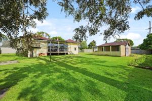ein altes Haus in einem Hof mit einer großen Rasenfläche in der Unterkunft Private King Bed, Walk To Beenleigh Village&Museum Bedroom3 in Yatala