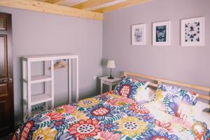 a bedroom with a bed with a colorful comforter at Nidos del Buitre - Apartamentos Rurales in Valencia de Alcántara