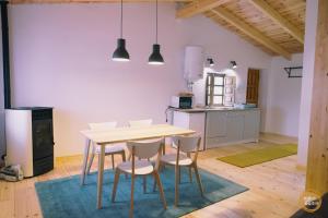 a kitchen with a table and chairs in a room at Nidos del Buitre - Apartamentos Rurales in Valencia de Alcántara