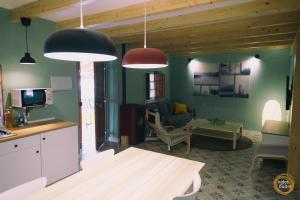 a kitchen with two pendant lights and a living room at Nidos del Buitre - Apartamentos Rurales in Valencia de Alcántara