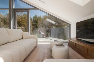 a living room with a white couch and a television at Japandi style luxury penthouse in Palanga