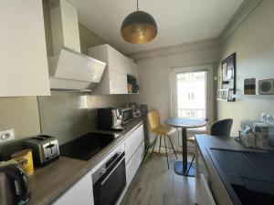 una cucina con un bancone e un tavolo di Superbe appartement à 5min du centre-ville a Dinan
