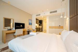 a bedroom with a large white bed and a desk at Cozy Canal View Studio in Dubai +21 photos
