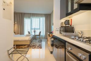 a hotel room with a kitchen and a bedroom at Cozy Canal View Studio in Dubai