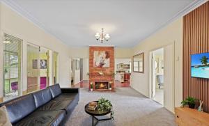 ein Wohnzimmer mit Couch und Kamin in der Unterkunft Cozy Queen Room Walk To Museum & Marketplace - Bedroom4 in Yatala