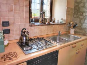Una encimera de cocina con una estufa y un fregadero. en Apartment on farm amidst the Umbrian hills, en Todi
