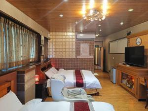 集集镇Jinge Guest House 集集金格民宿電動車充電站的一间有三张床和一台平板电视的房间
