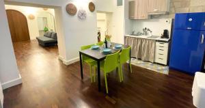 a kitchen and living room with a table and green chairs at Antica Muraglia Apartments in Molfetta