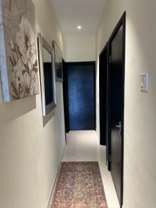 a hallway with a black door and a rug at Villa Christine in Ocho Rios