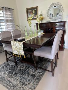 a dining room table with two chairs and a mirror at Villa Christine in Ocho Rios