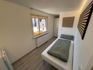 a small bedroom with a bed and a window at Casa Artisanos in Ehringshausen