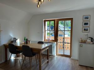 Un comedor con mesa y sillas y una ventana. en Apartma Vrbnjak, en Bohinj