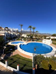 a view of a large swimming pool with palm trees at Casa Oasis in Nerja