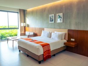 a hotel room with a bed and a large window at Kambaniru Beach Hotel and Resort in Waingapu +76 photos