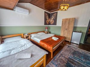 una camera con due letti e un tavolo in legno di OLDNEW Apartments & Rooms a Prizren