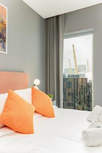 a bedroom with a bed with orange pillows and a window at ShySuite 1BED in London