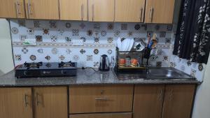 a kitchen counter with a sink and a stove at DNG Homes Cute studio apartment Polyview, Kisumu in Kisumu