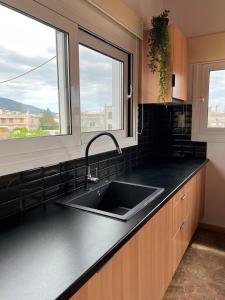 eine Küche mit Spüle und zwei Fenstern in der Unterkunft Sweet Home in Amarinthos + 5 Fotos