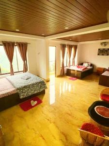 a large room with a bed and a living room at Nehal Royal Homestay in Kalimpong