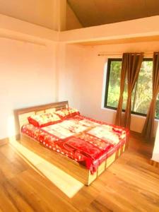 a bedroom with a bed in a room with a window at Nehal Royal Homestay in Kalimpong