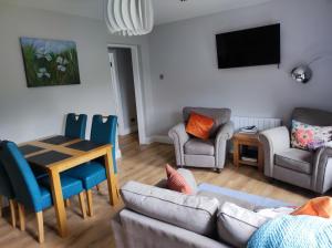 a living room with a couch and chairs and a table at Apartments at Ballinsheen House & Gardens in Lisdoonvarna