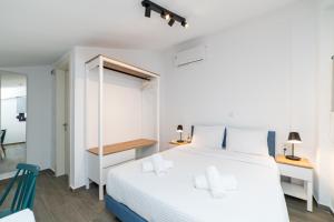 a bedroom with a large white bed with white pillows at Erato Residential Complex in Ofrínion