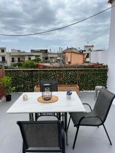 ein weißer Tisch und Stühle auf einem Balkon in der Unterkunft Sweet Home in Amarinthos