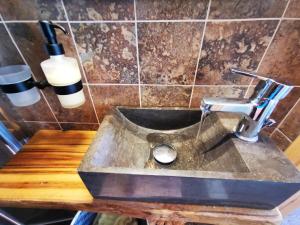 a sink in a bathroom with a wooden counter at Traditional stone guesthouse in Agios Andreas