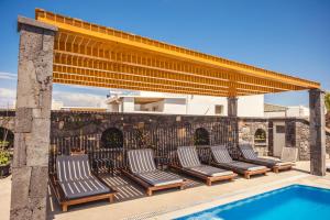 a group of chairs sitting next to a swimming pool at Cyclades Hotel in Karterados