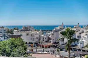 grupa białych budynków nad oceanem w obiekcie Apartamento Superior Alay en Puerto Marina playa w mieście Benalmádena