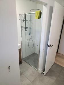 un bagno con doccia con porta in vetro di Maroochydore Delight a Maroochydore