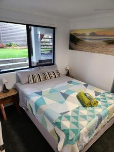 una camera da letto con un letto e una grande finestra di Maroochydore Delight a Maroochydore