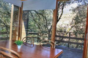 a wooden table and chairs on a porch with a large window at ARES Ecoresort in Camarasa